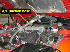 Suspended A/C suction hose